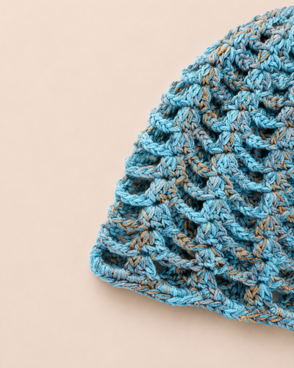 Close-up detail of The Capri Hat showing handmade crochet stitch texture and olive green metallic yarn with breathable mesh construction.