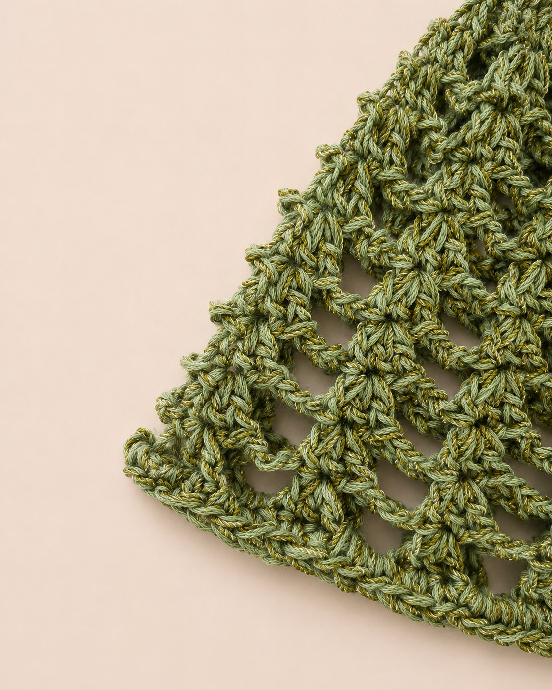 Close-up detail of The Capri Hat showing handmade crochet stitch texture and olive green metallic yarn with breathable mesh construction.