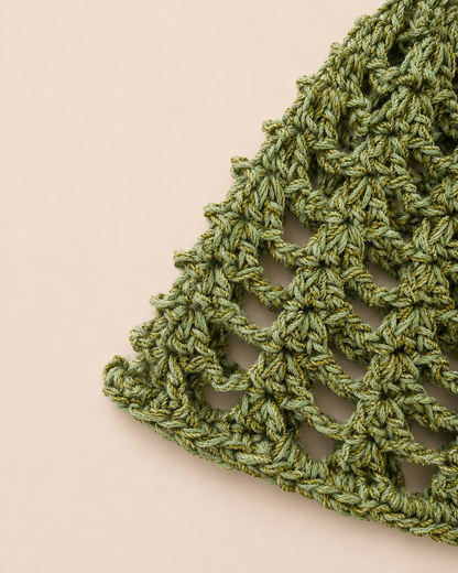 Close-up detail of The Capri Hat showing handmade crochet stitch texture and olive green metallic yarn with breathable mesh construction.
